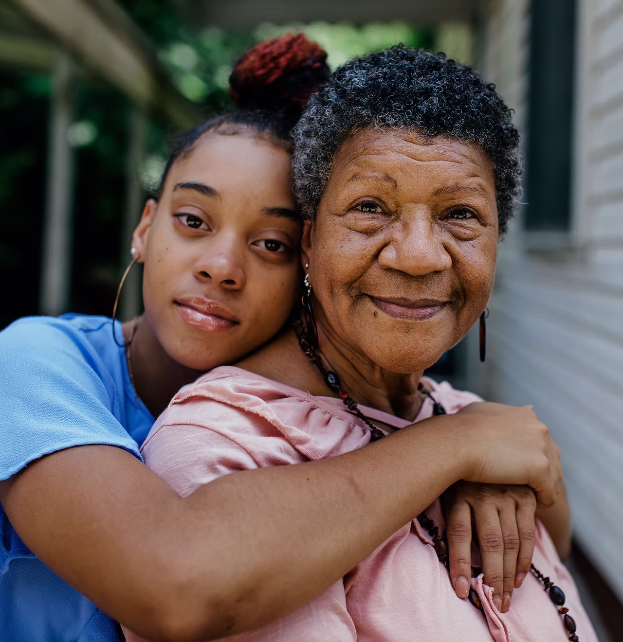 Nurse and family member supporting an older adult outside